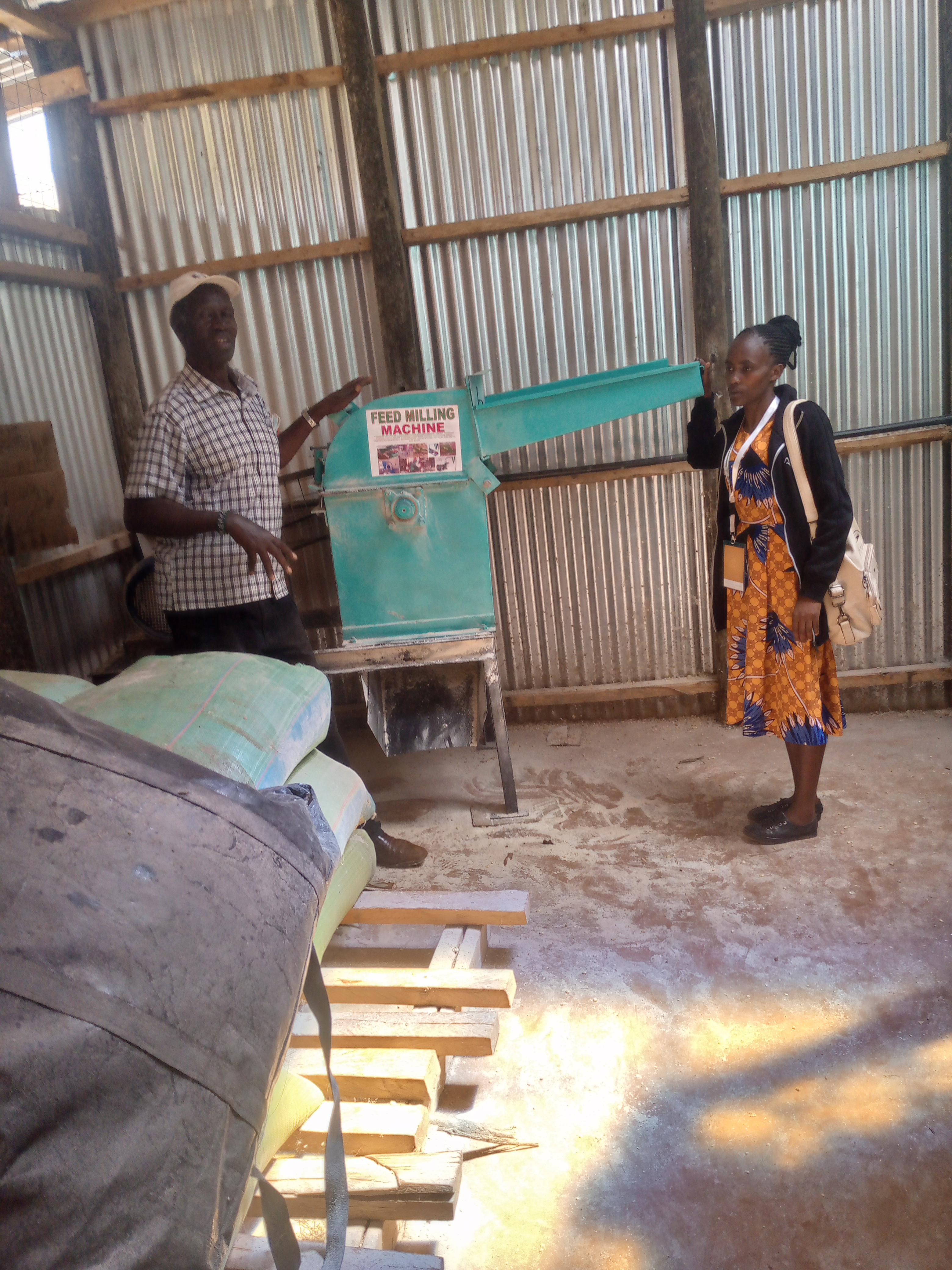 Explaining on how to use feed formulation machine to farmer.